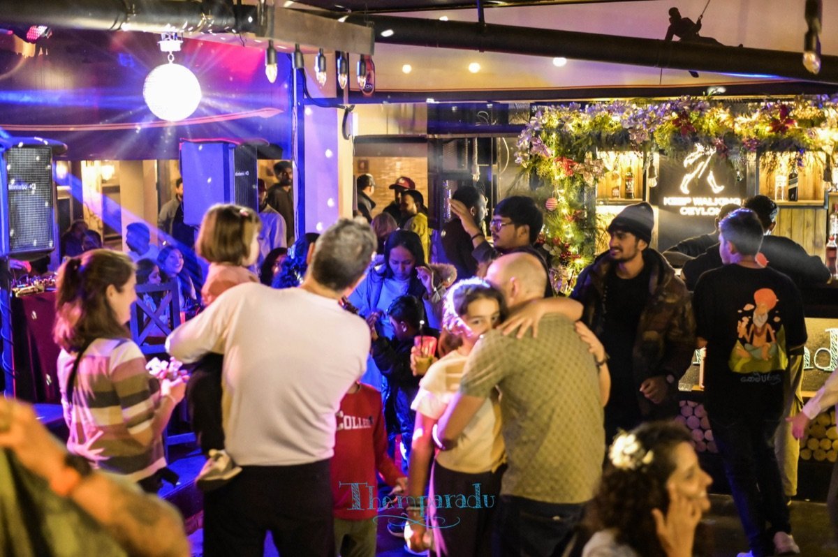 A crowd of all ages dancing under a disco ball